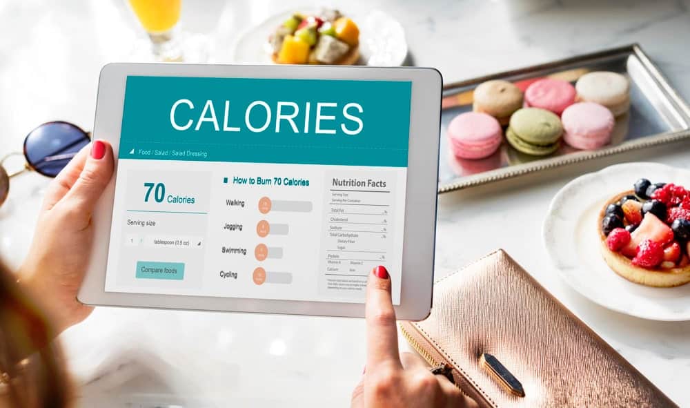 אישה מחזיקה אייפד שרשום עליו calories