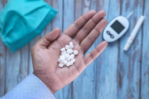 איש מחזיק כדורים ליד מד סוכר בדם