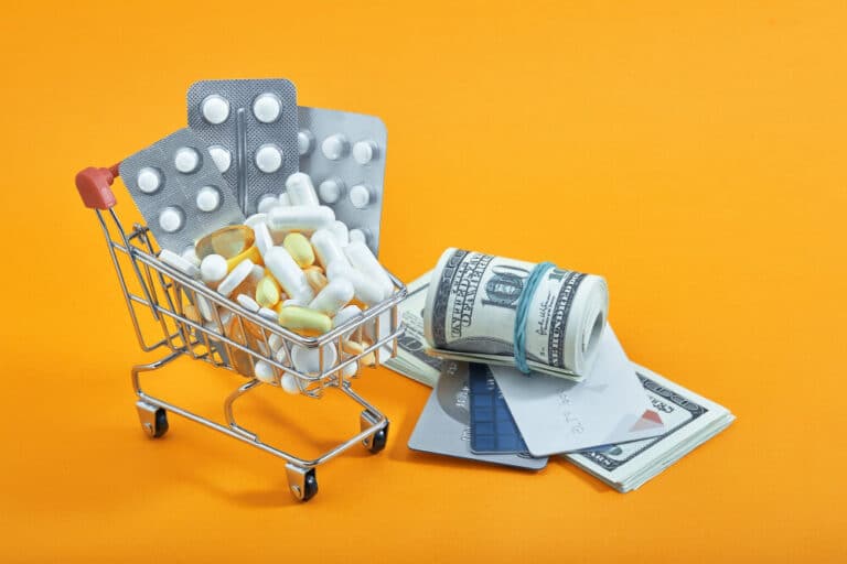 כדורים ותרופות בתוך עגלה ליד שטרות