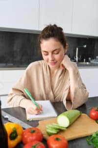 אישה רושמת מעקב שבועי בתהליך ירידה במשקל